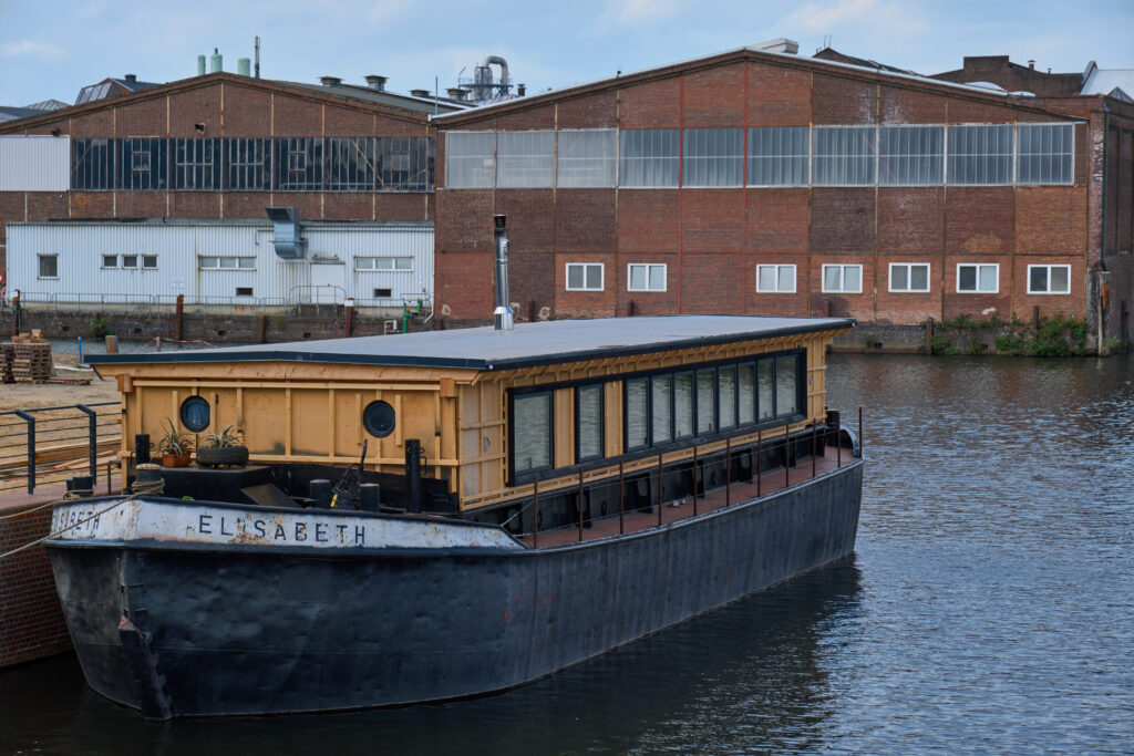 Ein Schiff mit dem Namen Elisabeth. Der obere Teil des Schiffes sticht durch seine kräftige gelbe Farbe hervor, während der untere Teil in Schwarz gehalten ist.