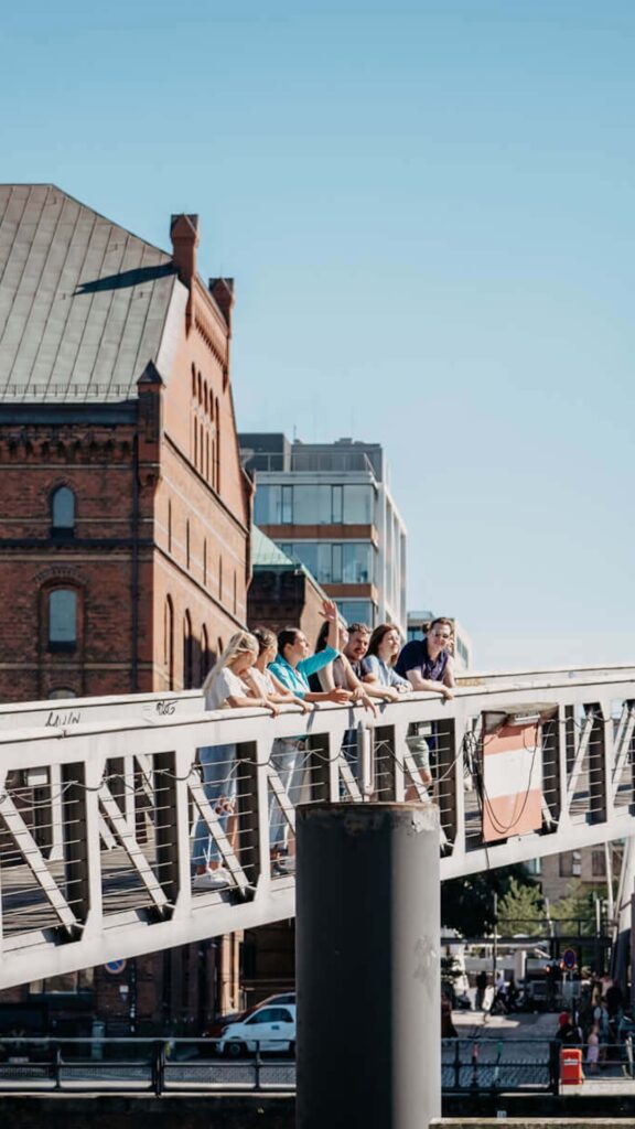 Eine Gruppe von Menschen steht auf einer Brücke, die sich über einen Fluss erstreckt.
