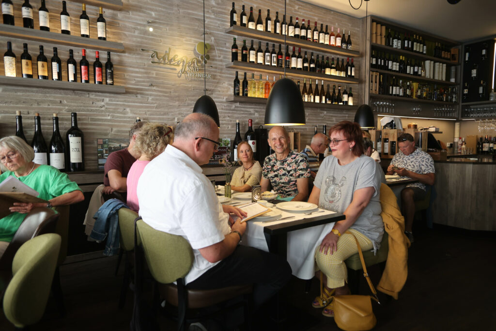 Eine Gruppe von Menschen sitzt im Restaurant und liest die Speisekarte.